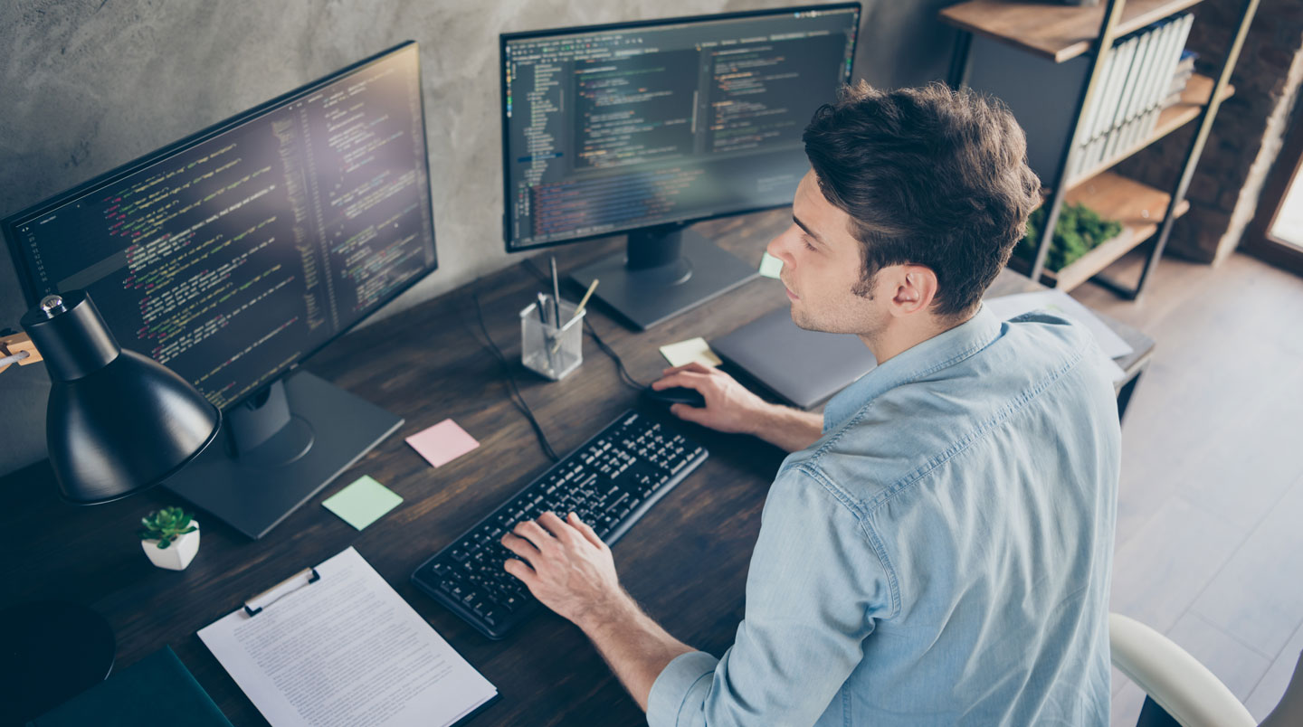 Développeuse travaillant sur une architecture logicielle cloud avec écrans multiples dans un bureau tech moderne